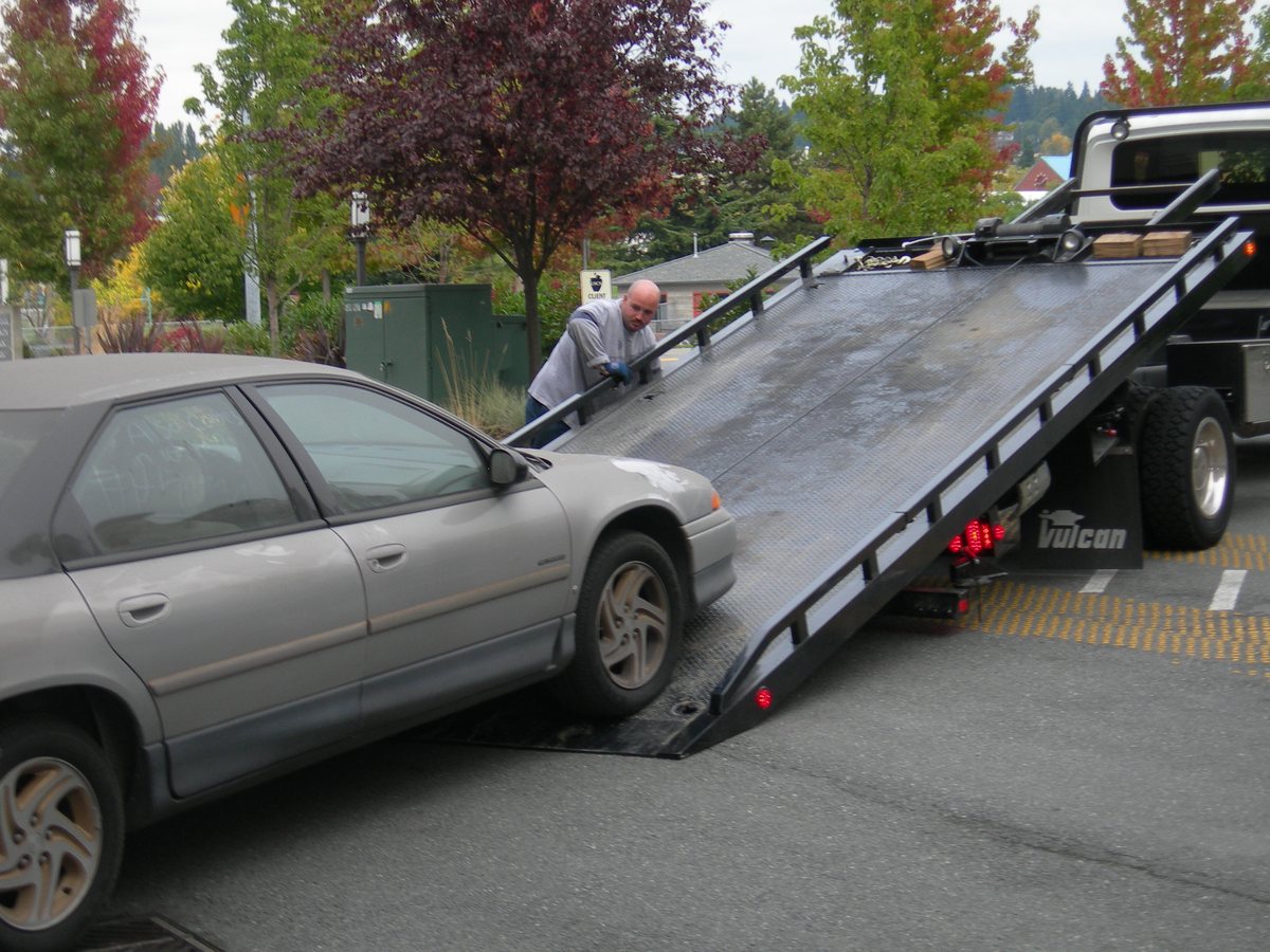 A car being loaded onto a flatbed tow truck